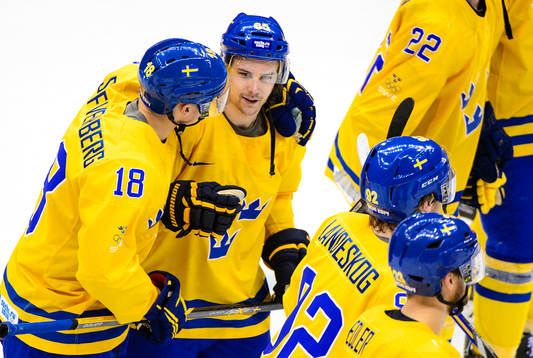 Sveriges Erik Karlsson klappas om av Sveriges Jakob