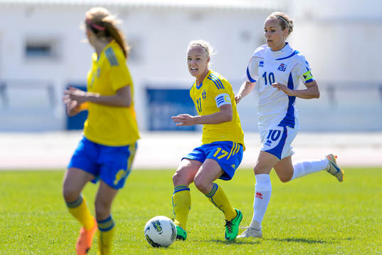 Sveriges Caroline Seger slår en passning framför Islands