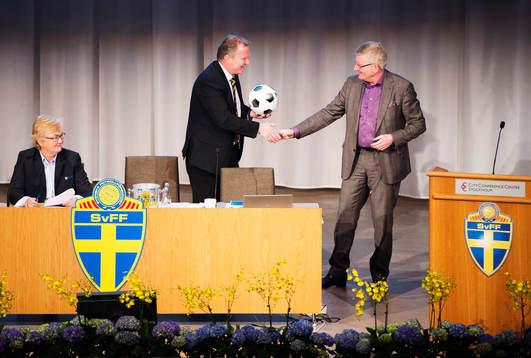 Karl-Erik Nilsson, ordförande, tar emot en fotboll av Hans Bredberg, advokat,