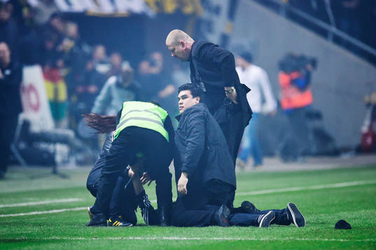 Säkerhetspersonal tar hand om en person som gett sig in