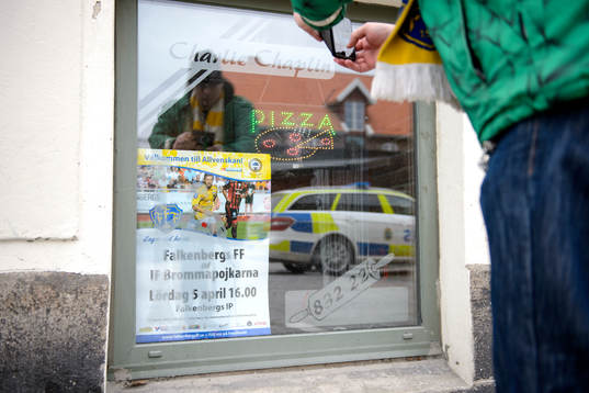 En supporter tar en bild på en affisch för Falkenbergs