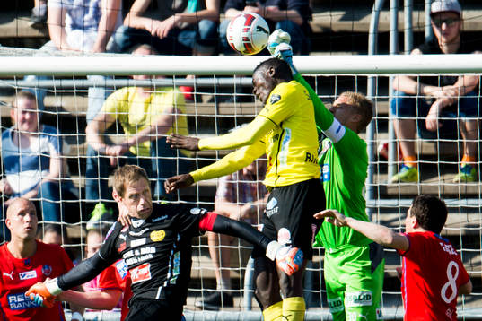 Helsingborgs målvatk Pär Hansson boxar ut bollen framför Mjällbys Kwame Bonsu och målvakt Mattias Asper
