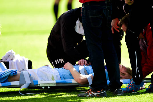Malmö FFs Simon Kroon lyfts ut på bår