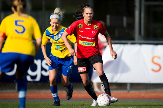 LB07s Josefine Rydle driver fram bollen jagad av Umeå Södras Emma Kullberg