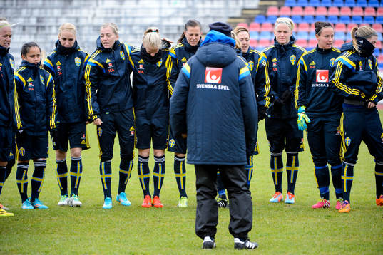 Laget är samlat och lyssnar på Sveriges förbundskapten Pia Sundhage (vänd från kameran)