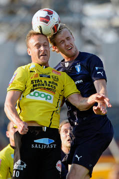 Mjällbys Marcus Ekenberg och Malmö FFs Filip Helander i den allsvenska matchen mellan Mjällby och Malmö FF i Hällevik 22 maj  2014.