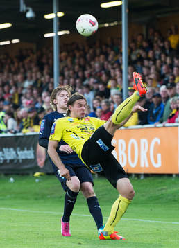 Mjällbys Danny Ervik bakåtsparkar framför Malmös Emil Forsberg i den allsvenska matchen mellan Mjällby och Malmö FF i Hällevik 22 maj  2014.