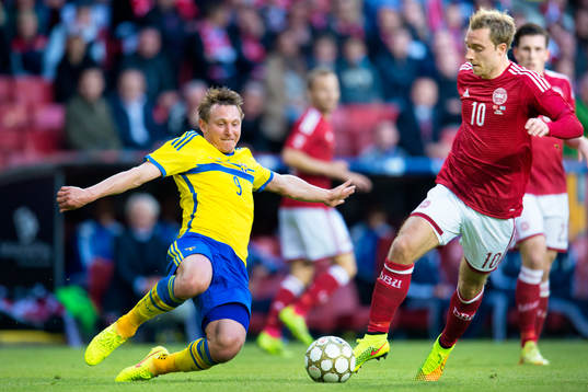 Sveriges Kim Källström jagar boll framför Danmarks Christian Eriksen