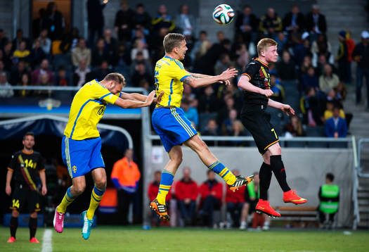 Sveriges Andreas Granqvist och Pontus Wernbloom i en luftduell med Belgiens Kevin De Bruyne