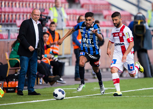 Assyriskas tränare Sören Åkeby ser på när Sirius Stefan Silva och Assyriskas Hezha Agai jagar bollen