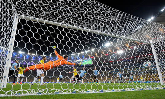 Colombias James Rodriguez gör 2-0 målet bkom Uruguays målvakt Fernando Muslera