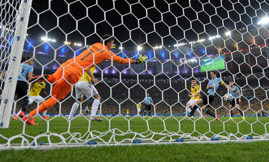 Colombias James Rodriguez gör 2-0 målet bakom Uruguays  målvakt Fernando Muslera