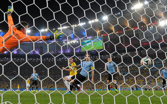 Colombias James Rodriguez gör 2-0 målet bakom Uruguays  målvakt Fernando Muslera