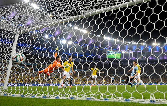 Colombias James Rodriguez gör 2-0 målet bakom Uruguays  målvakt Fernando Muslera