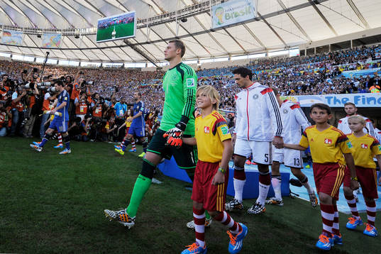 Tysklands målvakt Manuel Neuer och Argentinas Lionel Messi går in på planen inför finalen mellan Argentina och Tyskland