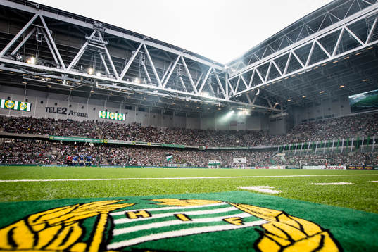 Hammarbys klubbmärke på en matta vid sidan av planen