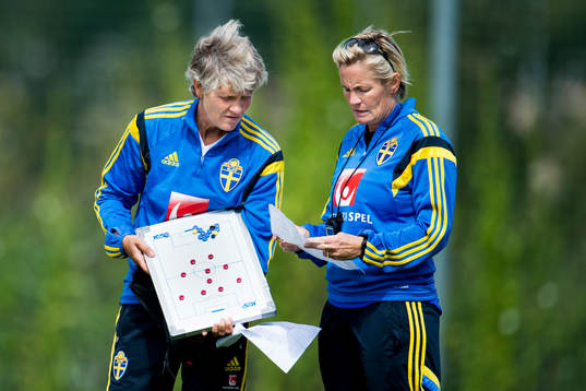 Sveriges förbundskapten Pia Sundhage med en taktiktavla och assisterande förbundskapten Lilie Persson