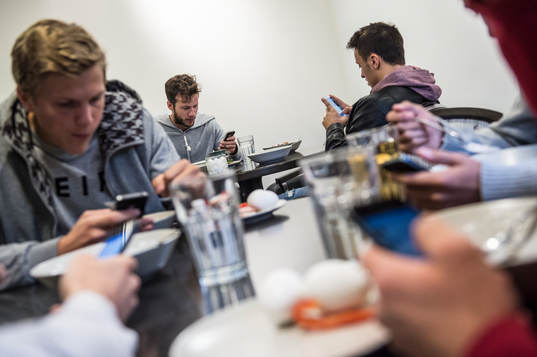 Robert Lundström, Adam Chenouffi och Joakim Nilsson tittar på sina telefoner