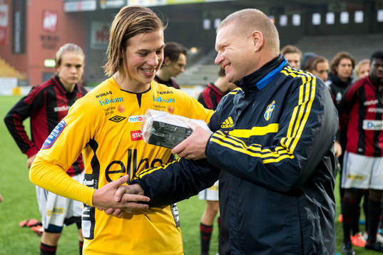 U17 landslagets förbundskapten Tomas Turesson delar ut pris till Elfsborgs Simon Olsson