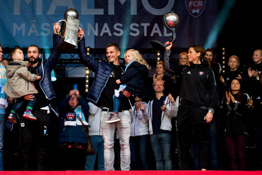 Malmö FFs Guillermo Molins och Markus Rosenberg höjer Lennart Johanssons Pokal och Rosengårds Sara Björk Gunnarsdottir höjer Kronprinsessan Victorias pokal när Malmö FF och Rosengård hyllas föra sina SM-guld den 2 november 2014 på Stortorget i Malmö.