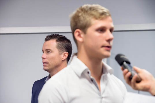 Sportchef Daniel Andersson tittar fram bakom Erik Andersson som intervjuas