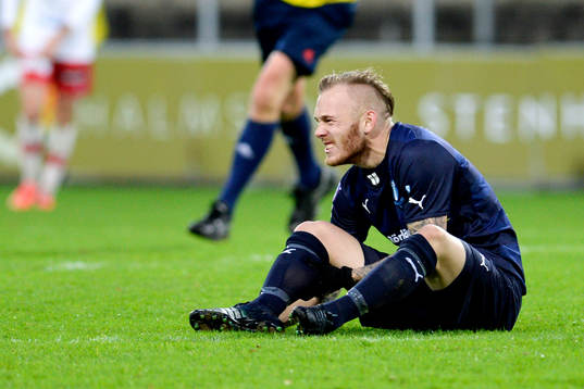 Malmö FFs Magnus Eriksson grinar illa efter att ha fått en smäll