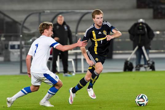 Sveriges Simon Gustafson går förbi Finlands Rasmus Schüllerunder träningsmatchen mellan Sverige och Finland den 19 januari 2014 i Abu Dhabi.