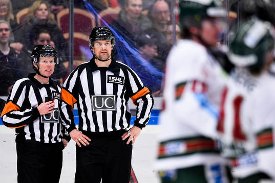 Domarna Pehr Claesson (tv) och Mikael Nord (th) tittar på