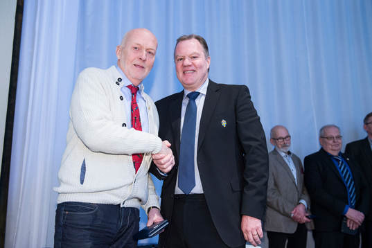 Rolf Olofsson tar emot en medalj för sina insatser för