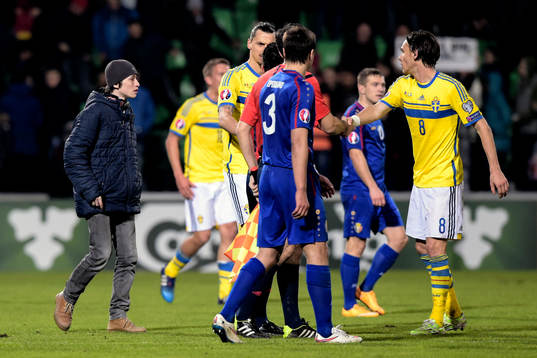 En kille springer in på planen och fram till Sveriges Zlatan Ibrahimovic och Albin Ekdal