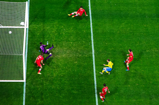 Sveriges Marcus Berg skjuter in 2-0 bakom Irans målvakt Alireza Haghighi