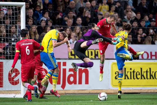 Irans målvakt Alireza Haghighi räddar framför Sveriges Erik Johansson