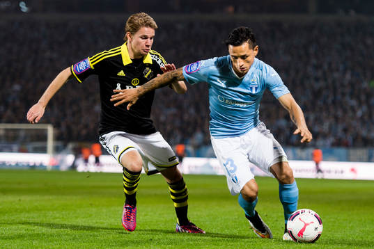 s Johan Blomberg och Malmö FFs Victor Yoshimar Yotun Flores under fotbollsmatchen i Allsvenskan mellan Malmö FF och AIK den 9 april 2015 i Malmö.