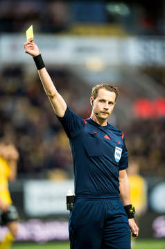 Domaren Andreas Ekberg visar gult kort