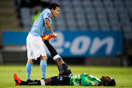 Malmö FFs Victor Yoshimar Yotun Flores hjälper Halmstads Joseph Baffo som har kramp