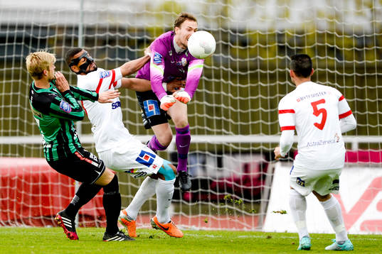 Assyriskas målvakt Robin Malmkvist rensar bort bollen framför Varbergs Mats André Kaland