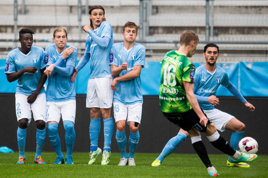Halmstads Eric Smith skjuter en frispark och Malmö FFs Pa Konate, Simon Kroon, Pawel Cibicki,  Mattias Svanberg och Agon Mehmeti står i mur