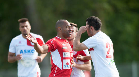 Höganäs Solo Hammar har sänkt en motståndare och Assyriskas Berahman Gholamreza pekar mot huvudet i matchen i division 2 Västra Götaland mellan Höganäs BK och Assyriska BK i Höganäs 7 juni 2015.
