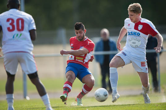 Höganäs Kastriot Sogajeva och Assyriskas Per Nylander i matchen i division 2 Västra Götaland mellan Höganäs BK och Assyriska BK i Höganäs 7 juni 2015.