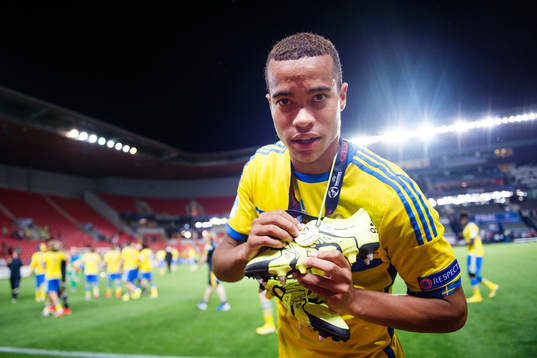 Sveriges Robin Quaison håller sin medalj mot hyllningen till sina vänner som är tryckt på hans sko