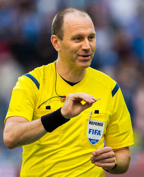 Domare Jonas Eriksson singlar slant innan fotbollsmatchen i