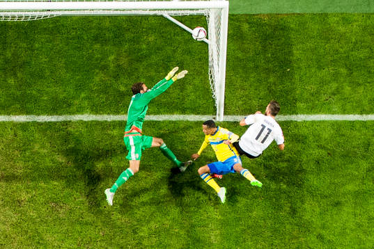 Österrikes Marek Harnik gör 0-2 bakom Sveriges målvakt Andreas Isaksson i kamp med Martin Olsson