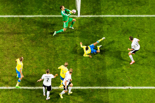 Sveriges målvakt Andreas Isaksson gör en räddning på skott från Österrikes Marek Harnik (th)