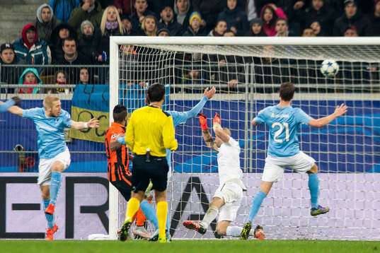 Shakhtar Donetsks Alex Teixeira gör 4-0 bakom Malmö FFs målvakt Johan Wiland i kamp med Anton Tinnerholm och Kari Arnason