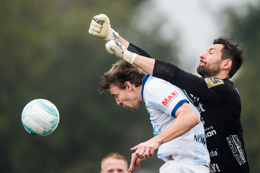 Halmstads målvakt Stojan Lukic boxar bort bollen i kamp med Gefles Johan Oremo