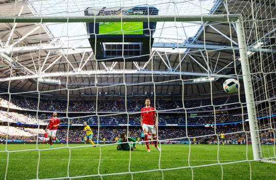 Sveriges John Guidetti skjuter in 3-0 bakom Wales målvakt Daniel Ward