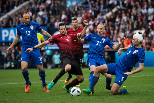 Turkiets Hakan Balta i en duell med Kroatiens Gordon Schildenfeld, Domagoj Vida och Vedran Corluka