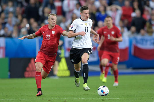 Polens Kamil Grosicki i närkamp med Tysklands Julian Draxler i fotbollsmatchen mellan Tyskland och Polen