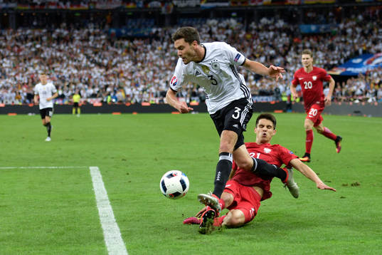 Tysklands Jonas Hector glidtacklat av Polens Michal Pazdan i fotbollsmatchen mellan Tyskland och Polen