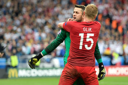Polens målvakt Lukasz Fabianski kramas om av Kamil Glik efter fotbollsmatchen mellan Tyskland och Polen